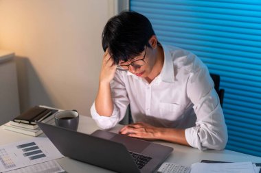 Fazla mesai. Masasında oturan, gözlüğünü çıkaran ve çalışırken kafasını tutan adam hariç..