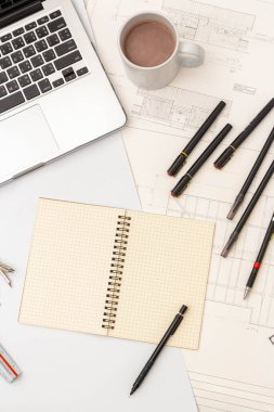 Mimari konseptin modeli, çizim araçları ve tasarım mühendisliği üzerine sıcak kahve.