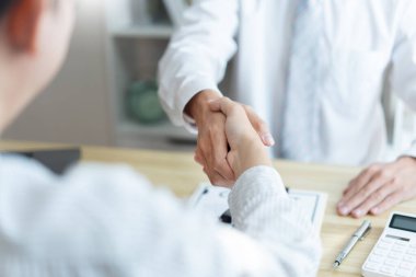 Sigorta konsepti araba komisyoncusu sözleşmeyi bitirdikten sonra müşterisiyle el sıkışıyor..