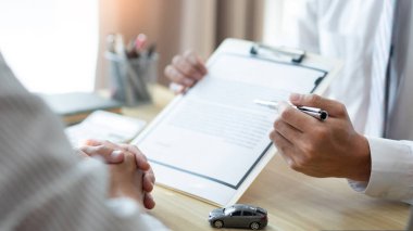 Otomobil satıcısının müşterisinin sözleşmesini vurguladığı sigorta konsepti.