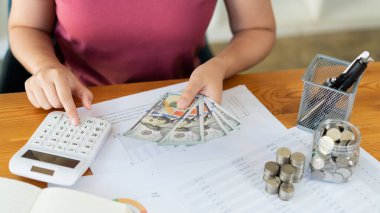 Kadın kurtarıcı para miktarını hesaplamak için hesap makinesine basıyor.