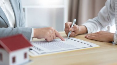 Sigorta konsepti, emlakçının müşterisine ev satın alma sözleşmesini okumasıdır..