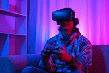 Metaverse teknoloji konsepti, insan sanal dünyada oyun oynamak için VR gözlük takar ve joystick kullanır.
