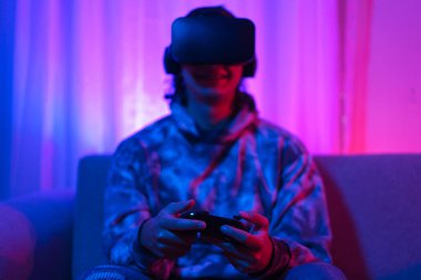 Metaverse teknoloji konsepti, insan VR gözlük takar ve metaevrende spor oyunları oynamak için joystick kullanır.