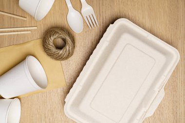 Çevre dostu konsept, yiyecek kabı seti ve tahta zemin üzerinde kağıt bardak ile jute halat.