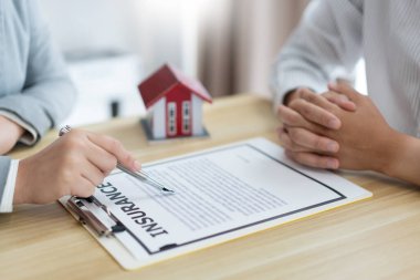 Sigorta konsepti, emlakçının müşterisine ev satın alma sözleşmesini okumasıdır..