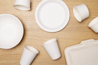 Çevre dostu kavram, yiyecek kabı seti ve tahtadan arka planda biyolojik olarak çözünebilen kağıt bardak..