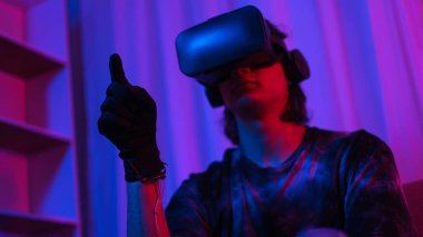 Metaverse teknoloji konsepti, insan oyun oynarken jest yaparken VR gözlük ve eldiven takar.