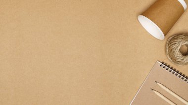 Çevre dostu kavram, kağıt bardak jüt ip ve tahta zemin üzerine kalem ile not defterinden oluşur..