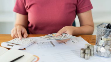 Kadın kurtarıcı para miktarını hesaplamak için hesap makinesine basıyor.