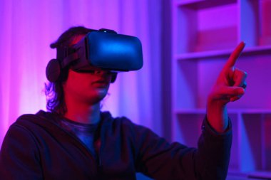 Metaverse teknoloji konsepti, insan VR gözlük takar ve sanal dünyada dokunma deneyimine işaret eder.