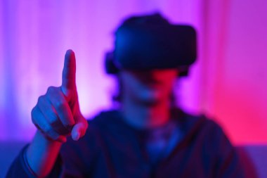 Metaverse teknoloji konsepti, insan VR gözlük takar ve sanal dünyada dokunma deneyimine işaret eder.