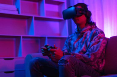 Metaverse teknoloji konsepti, insan VR gözlük takar ve metaevrende spor oyunları oynamak için joystick kullanır.