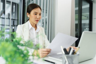 Kendine güvenen kadın konsepti, iş kadını iş dünyasının karını hesaplamak için finansal belgeyi okuyor.