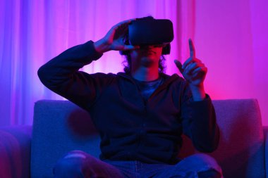 Metaverse teknoloji konsepti, VR gözlükleri tutan ve metaevren deneyimini işaret eden adam..