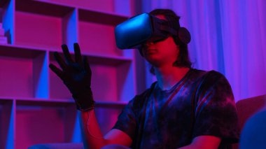 Metaverse teknoloji konsepti, insan oyun oynarken jest yaparken VR gözlük ve eldiven takar.