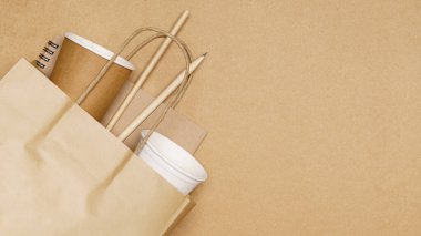 Çevre dostu kavram, kalem ve kağıt bardakla tahta arka planda pipetler..