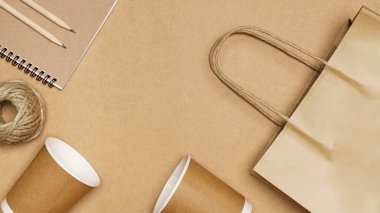 Çevre dostu kavram, kağıt torba kağıt bardak jüt ip ve tahta zemin üzerinde kalem ile defter.