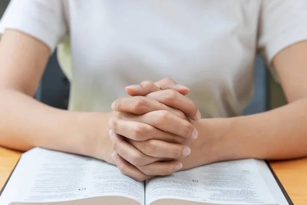 Pray and religion concept, Female christian hands folded and read bible to praying for spirituality.