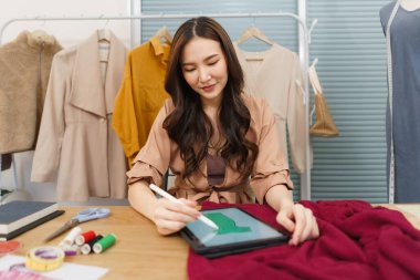 Moda tasarımı konsepti, Asyalı kadın moda tasarımcısı yeni elbise koleksiyonu çizmek için tablet kullan.