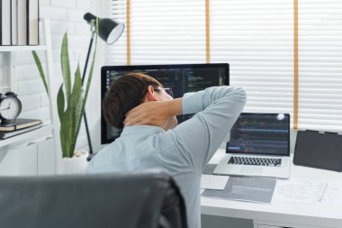 Yazılım geliştirme konsepti, bilgisayar üzerinde çok çalıştıktan sonra boyun ağrısı çeken erkek programcı..