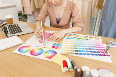 Moda tasarımı konsepti, Asyalı kadın moda tasarımcısı renk seçer ve yeni elbise koleksiyonu çizer.
