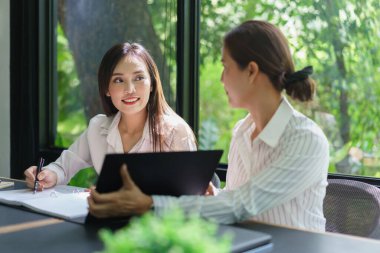 İş arkadaşı konsepti ve iş kadınlarının iş arkadaşlarıyla proje tartışması için tuttukları dosya..