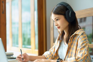 Education and literacy concept, College student girl watching lecture online and taking notes.