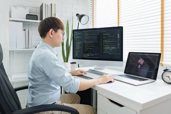 Yazılım geliştirme kavramı, uygulama ve web sitesi geliştirmek için dizüstü bilgisayarda veri yazan erkek programcı.