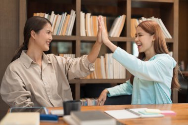 Eğitim konsepti, Bayan özel öğretmen dersten sonra öğrenciyle kutlamak için beşlik çakıyor..
