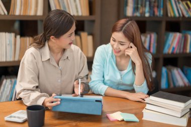 Eğitim konsepti, tablette matematik sınavına işaret eden ve öğrencilere matematik dersi veren kadın öğretmen..