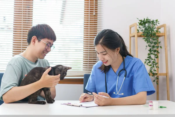 Pet Care Concept Female Veterinary Examining Cat Writing Prescription Clipboard — ストック写真