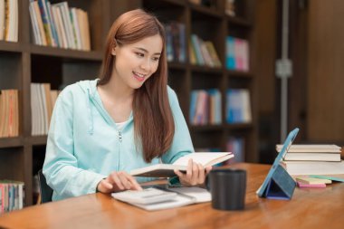 Education concept, Teenage girl watching video math tutorial and use calculator to doing math quiz.