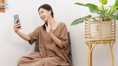 Rahatlama yaşam tarzı konsepti, akıllı telefon kullanan genç Asyalı kadın..