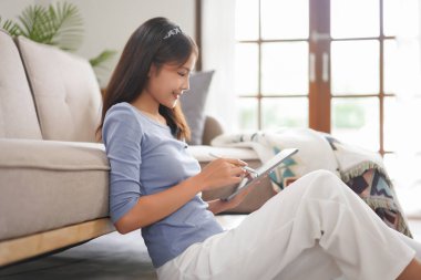 Work from home concept, Business women reading financial data on tablet while work remotely at home.