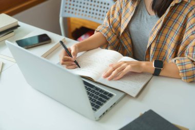 Education and literacy concept, College student girl watching lecture online and taking notes.