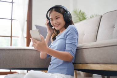 Work from home concept, Business women is relaxation to listening music on smartphone at home.