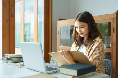 Eğitim ve okur yazarlık konsepti, üniversiteli kız dizüstü bilgisayar dersleri alıyor ve notlar alıyor..