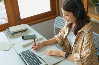 Education and literacy concept, College student girl watching lecture online and taking notes.