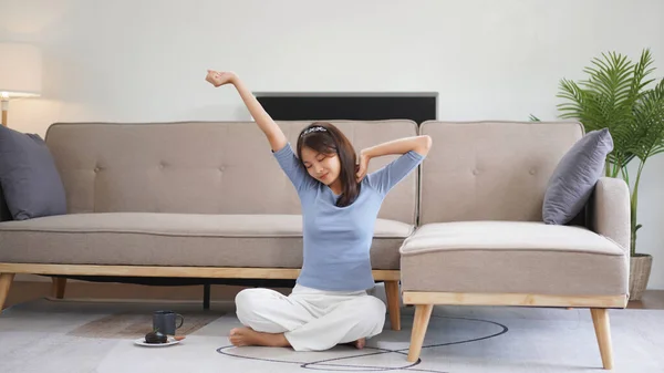 Work from home concept, Business women sit on floor and stretching to relax after working at home.