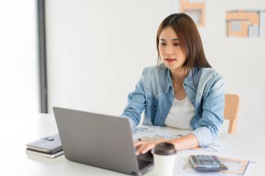 Construction business plan concept, Female architect is drawing house plan of project on laptop.