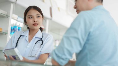 Medicine and health concept, Female pharmacist explains medicinal properties to client in drugstore.