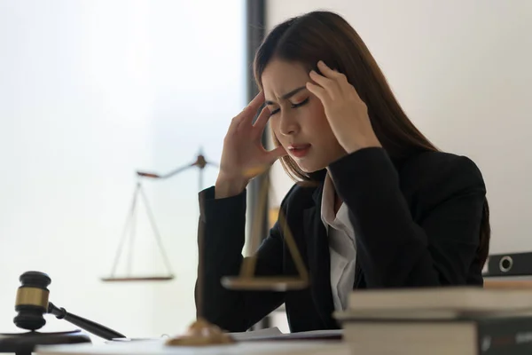 Legal and justice concept, Female lawyer stressful and headache while reading contract of business.