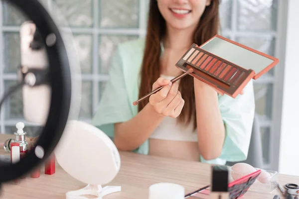 Beauty blogger concept, Young woman apply eyeshadow to introduce product and record video for Vlog.