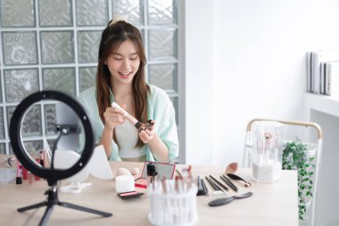 Güzellik Etkilendirici Konsepti, genç kadın, Vlog 'a başvurmak ve gözden geçirmek için sıvı fondöten kullanır.