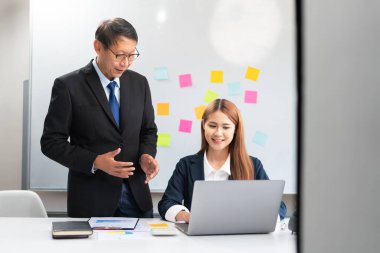 Business partnership concept, Senior in business is explaining project data on laptop to partner.