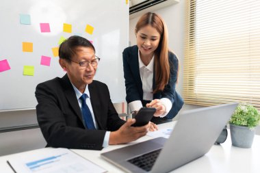 Business partnership concept, Business senior read data on smartphone while discussing with partner.