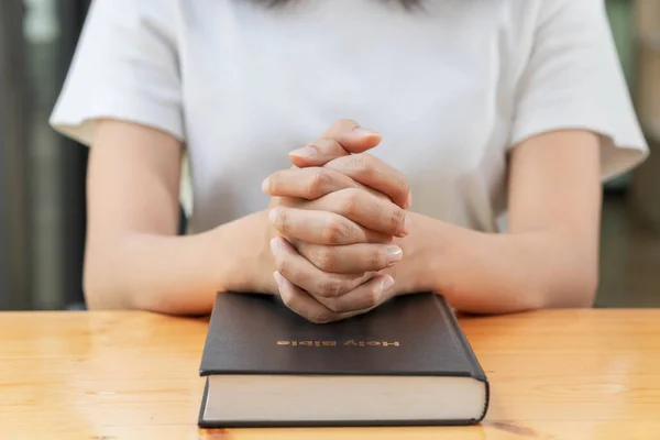 Pray and religion concept, Female christian hands folded on holy bible to prayer for spirituality