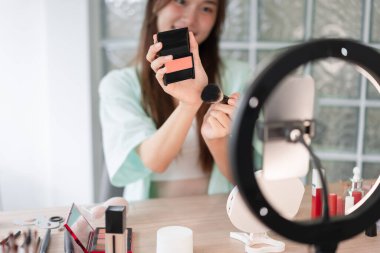 Beauty Vlogger konsepti, genç kadın Vlog için ürün ve kayıt videosu tanıtmak için kızartıcı uygula.