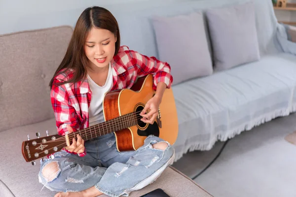 ⬇ Скачать Картинки A Girl Playing Guitar In The House, Стоковые.